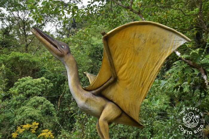 dinosaur statue with jungle surround