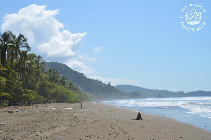 dominical beach with green mountains behind
