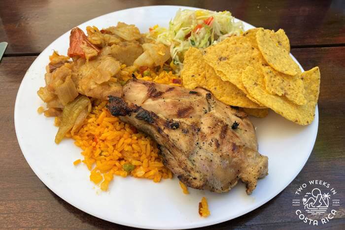 plate of food with chicken, rice, potatoes, and corn chips