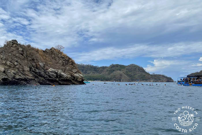 A large group snorkeling in the distance