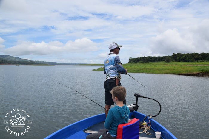 A boy and a man fishing from a bass boat