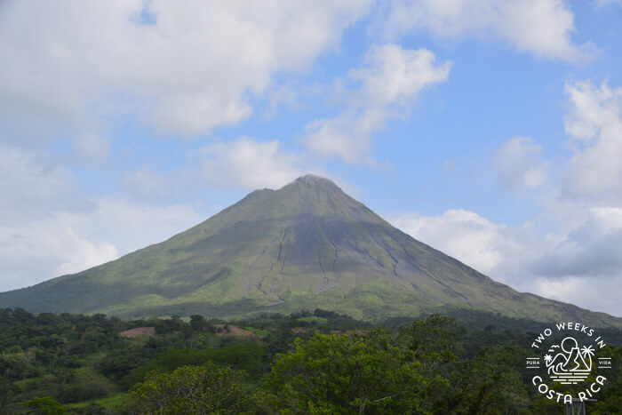 The cone-shaped Arenal Volcano with greenery all around the base