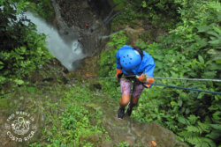 rappelling down cliff with waterfall pool below arenal
